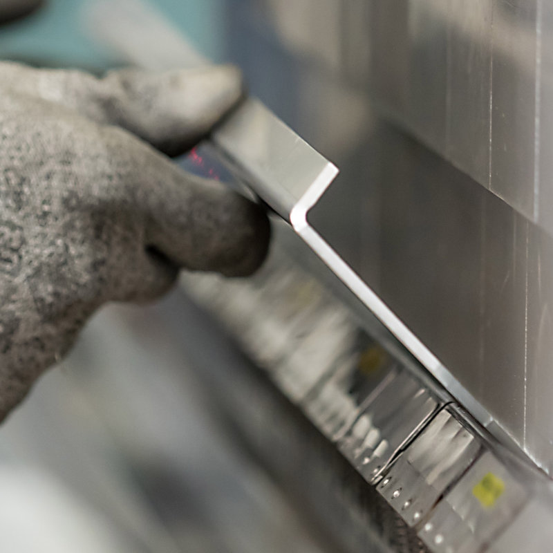 Mitarbeiter verformt ein Metallblech